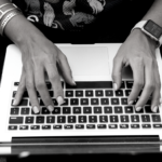 Person's hands typing on a laptop