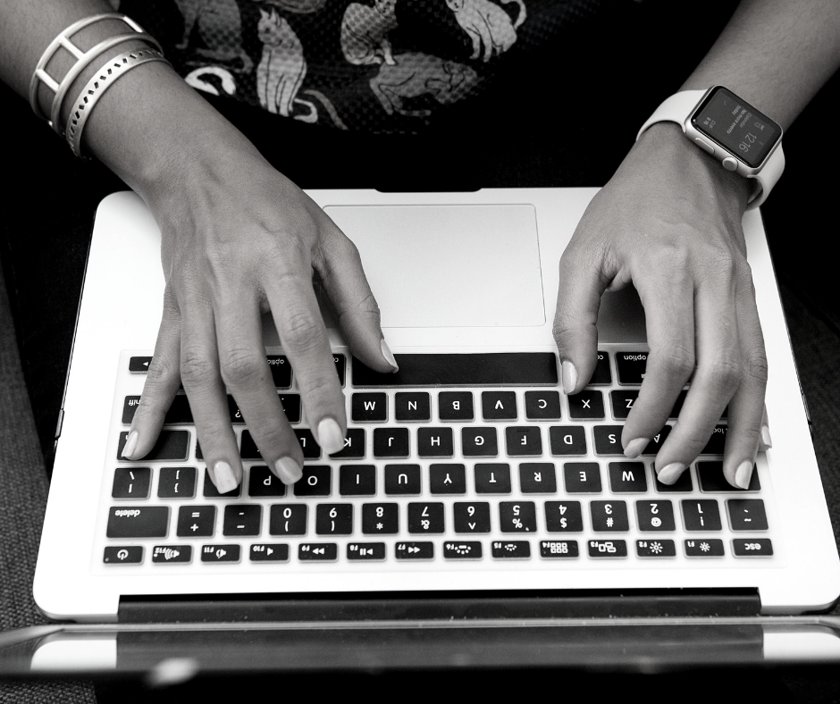 Person's hands typing on a laptop